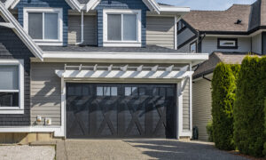 Black garage door on a home with tan siding